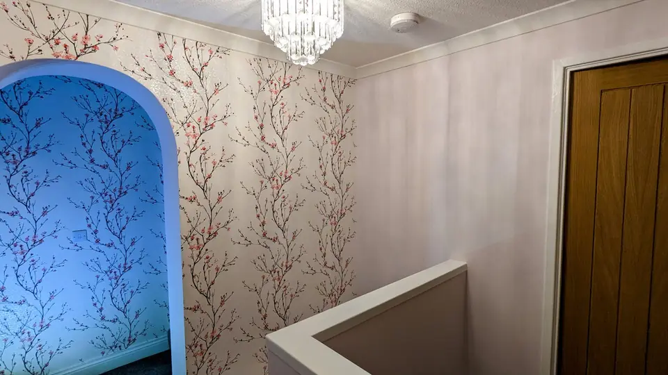 Blossom wallpaper on a landing with a painted archway alcove