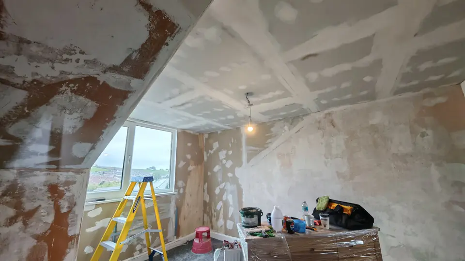 Before: wallpaper stripped, slopes and walls patched and filled