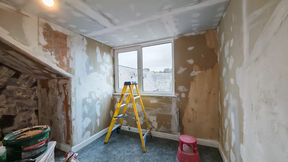 Before: window wall stripped and filled, ladder in place