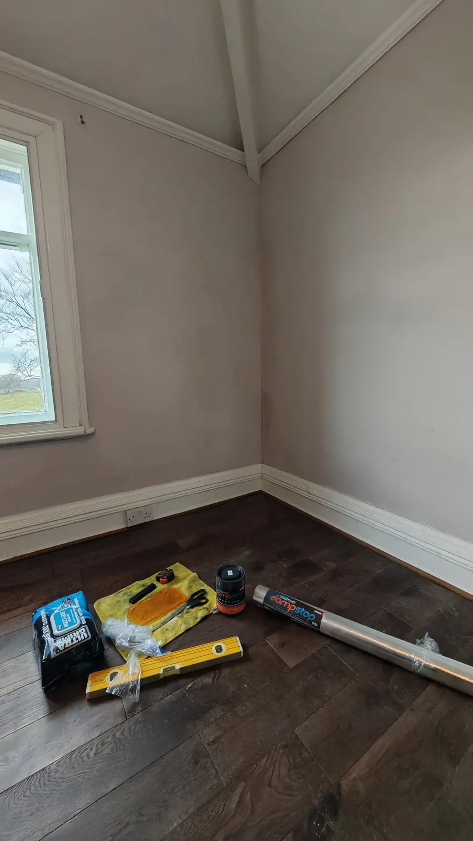 Before: bare attic bedroom wall, with the materials laid out ready
