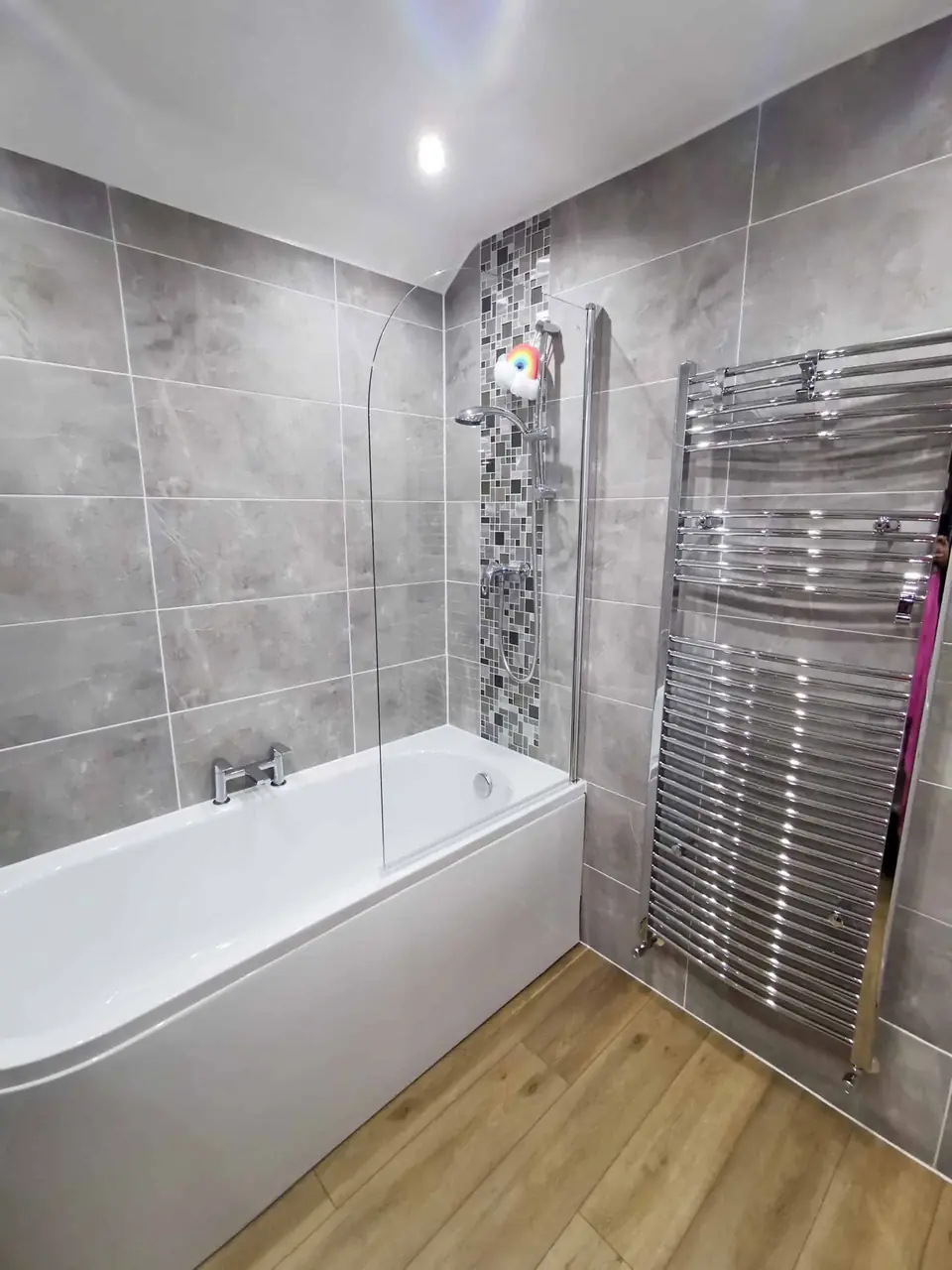 Bathroom with mosaic tile strip and chrome towel radiator