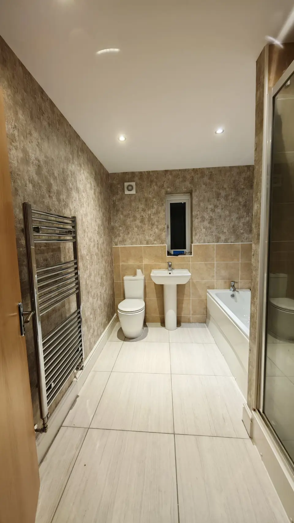 Bathroom hung with textured bronze wallpaper