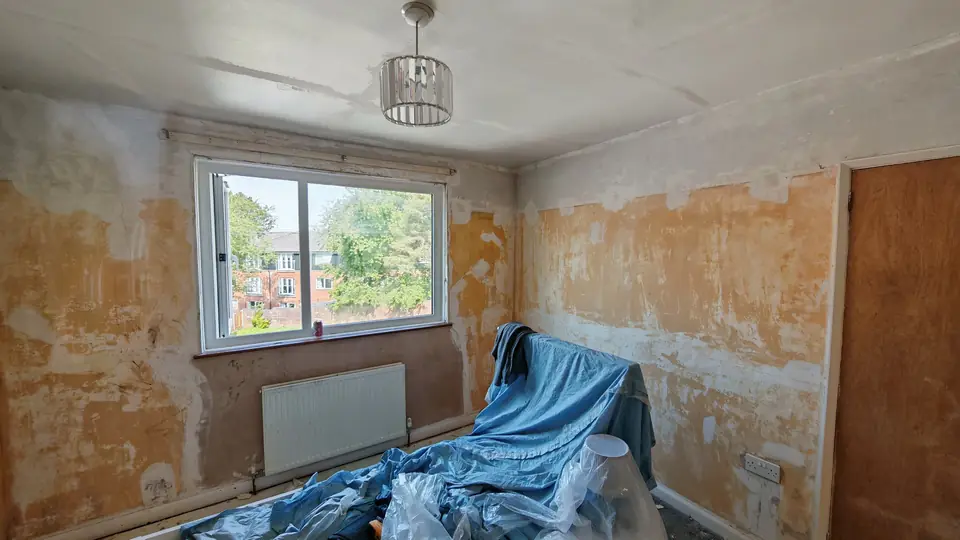 Before: bedroom stripped back with patched and filled walls