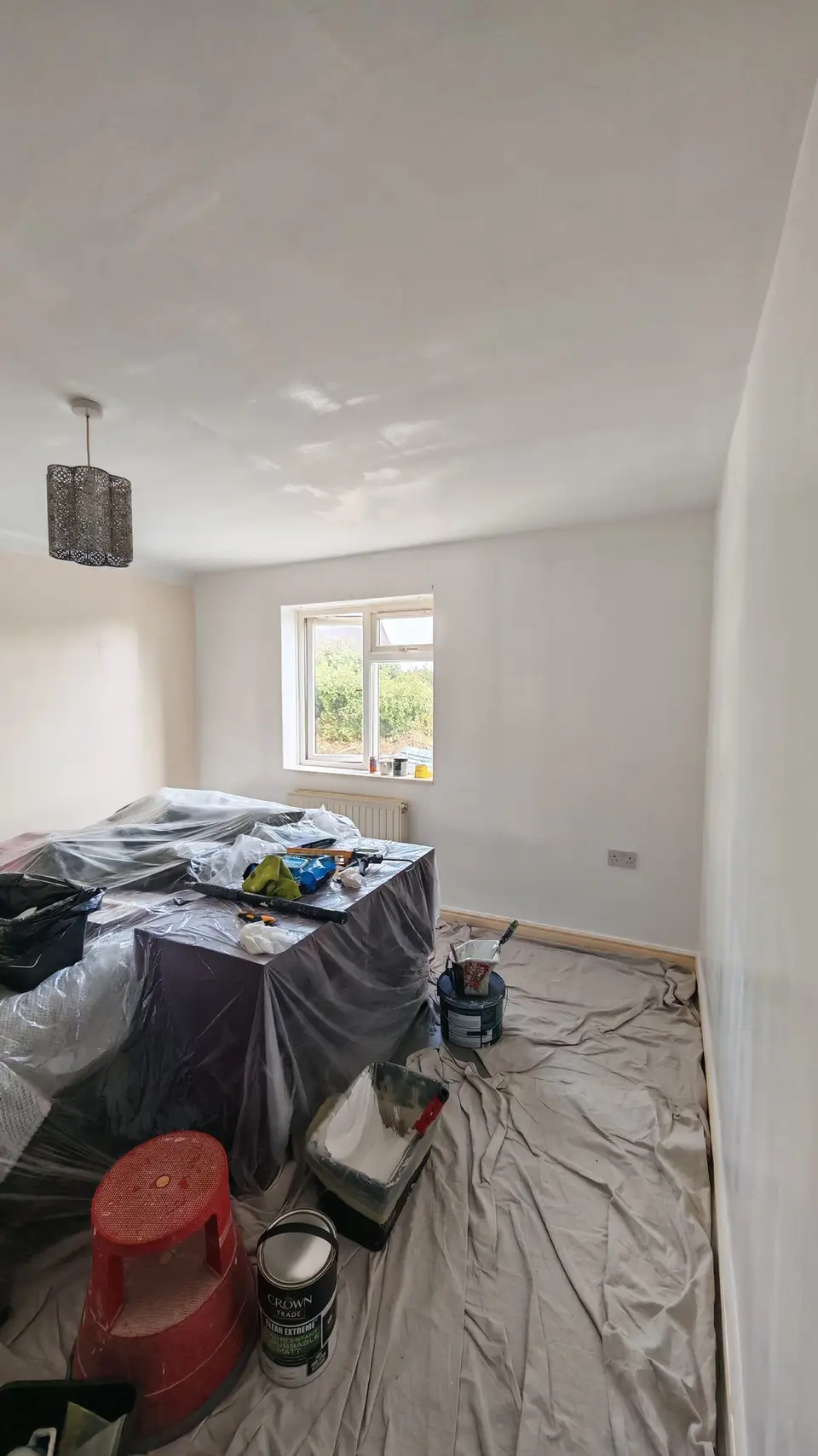 During: white walls by the window, dust sheets down