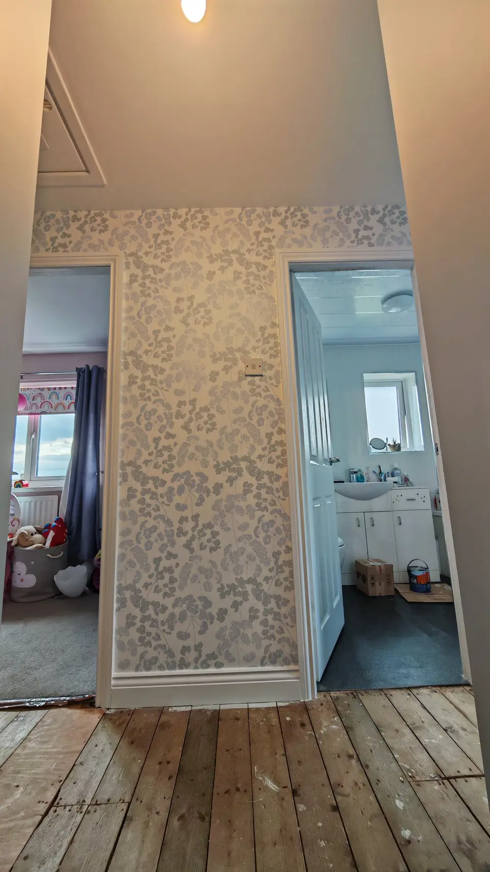 Landing feature wall in floral wallpaper between white door frames