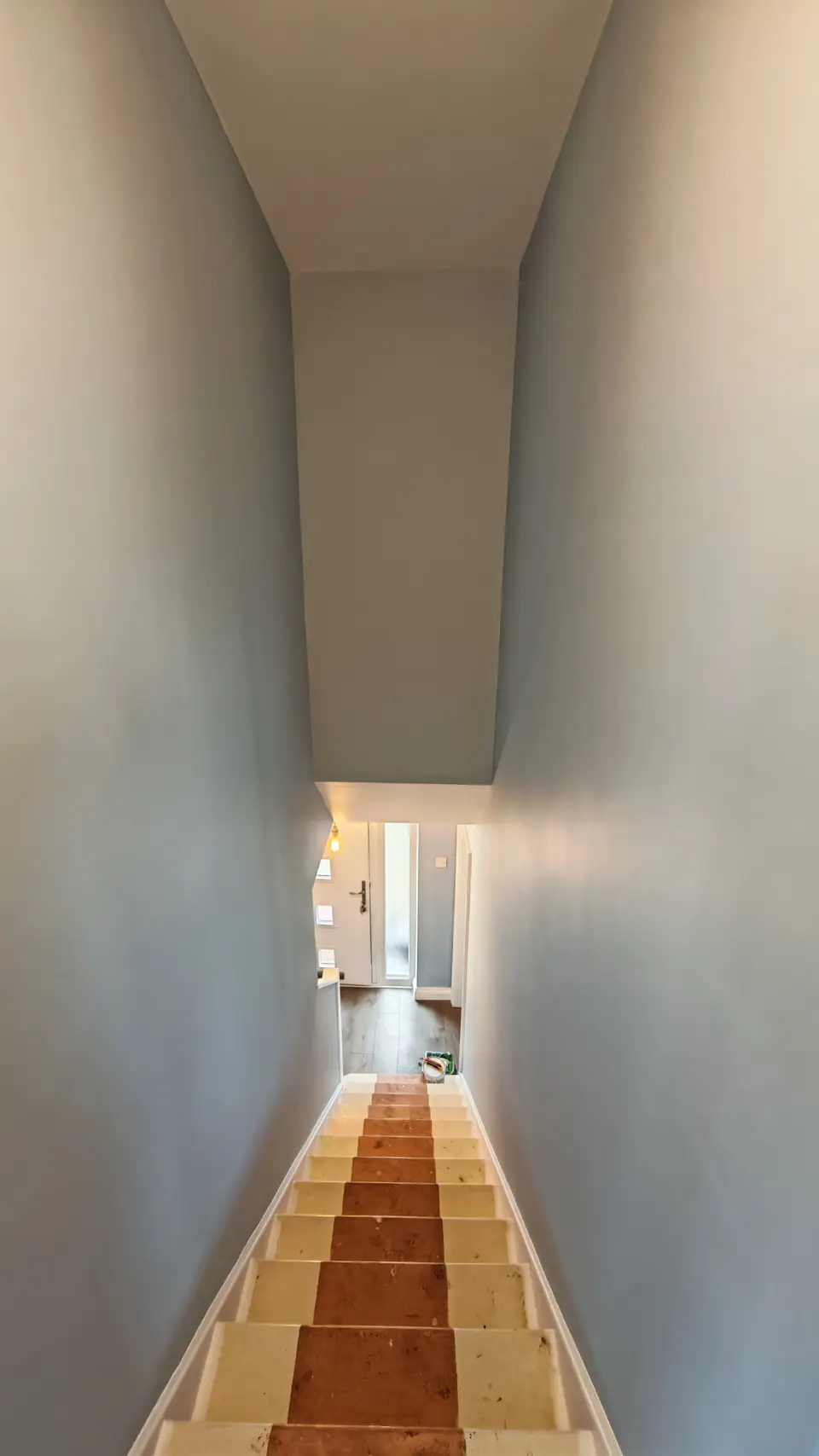 Stairwell painted soft blue-grey, white ceiling and stringers