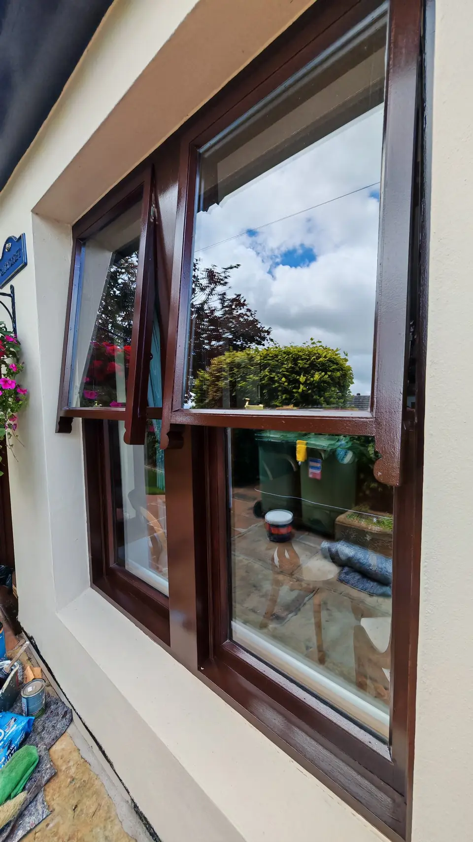 Close-up of windows refinished in brown gloss against cream render