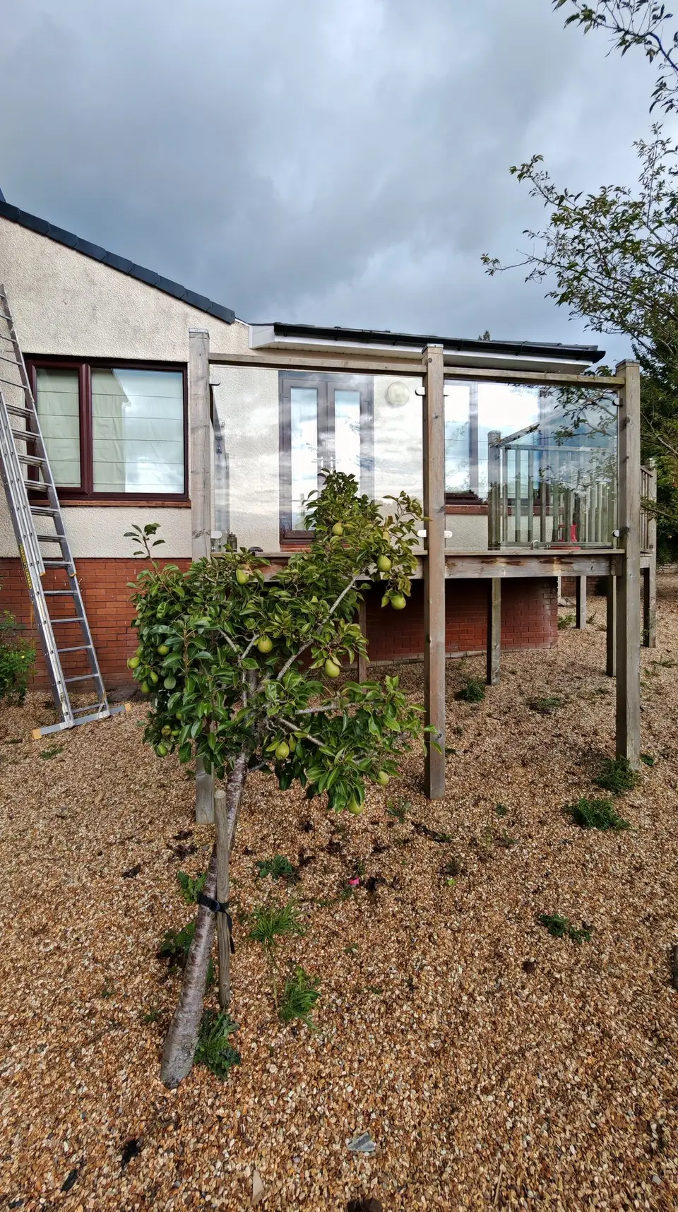 Before: rear of the bungalow in cream render, ladder up