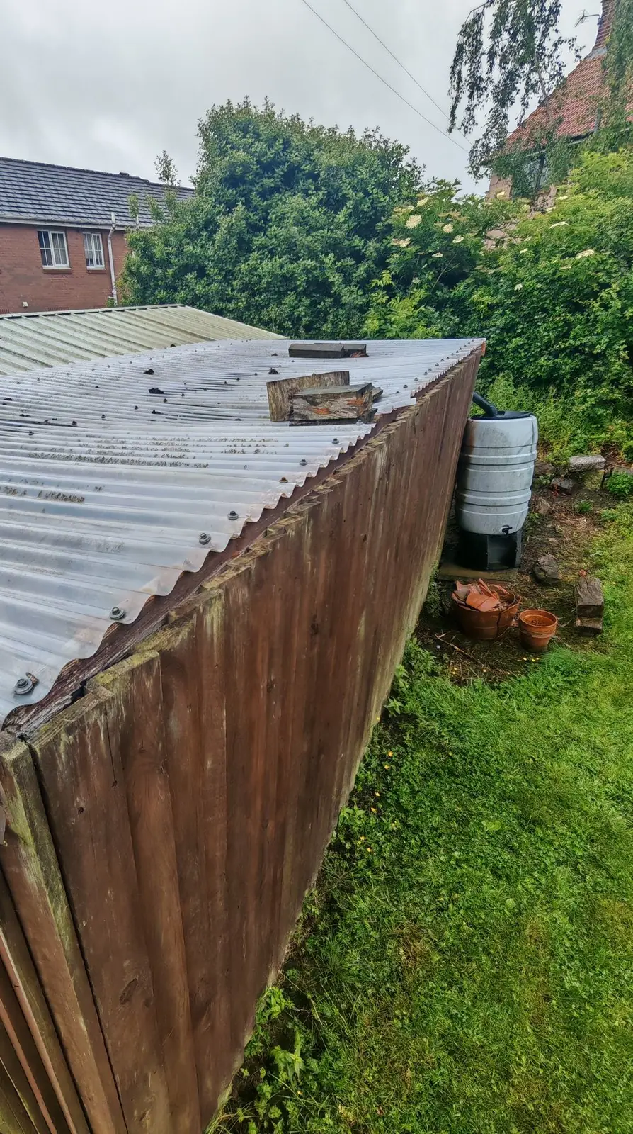 Before: weathered corrugated canopy roof with debris on top