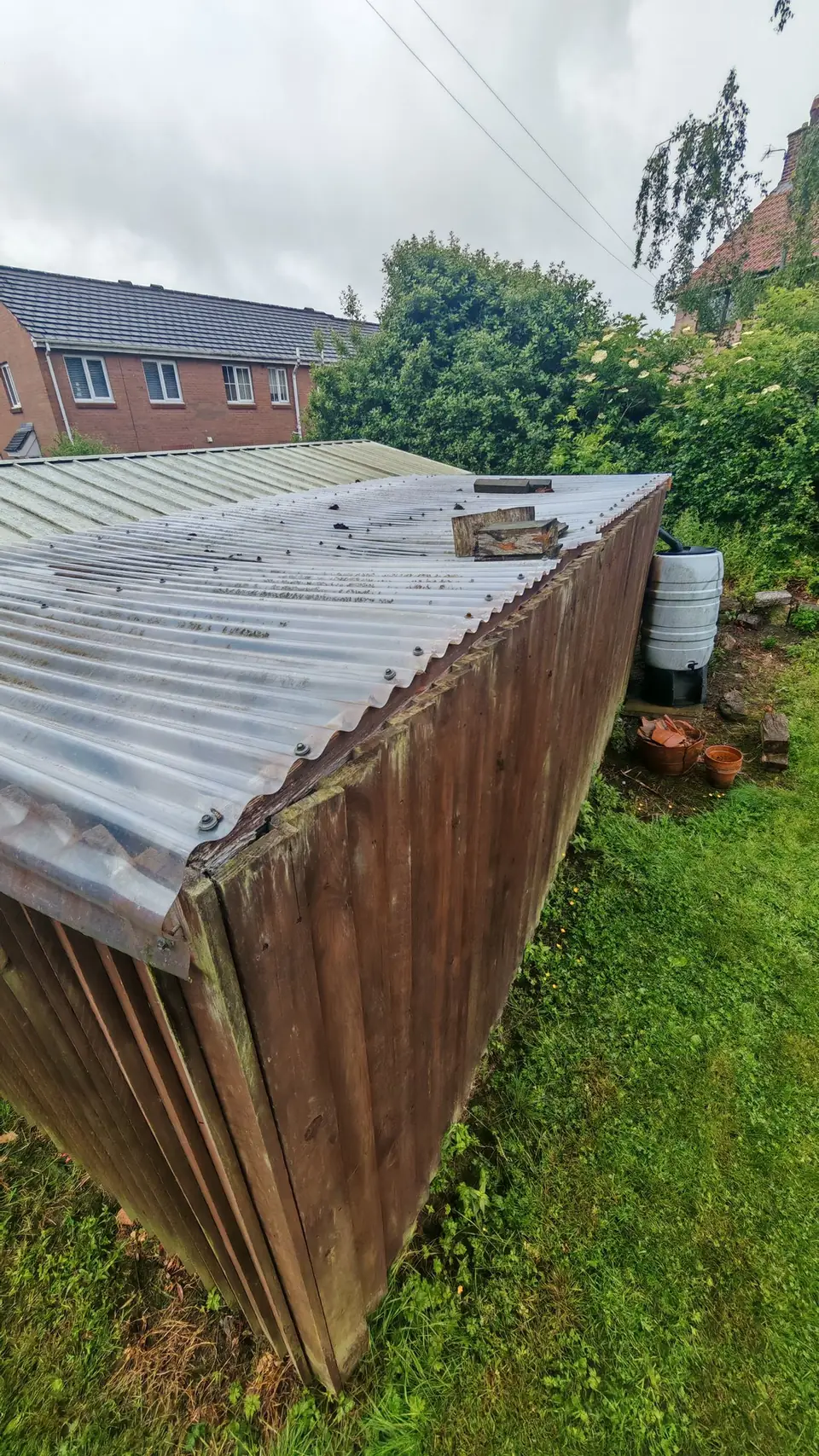 Before: old weathered corrugated canopy roof with debris on top