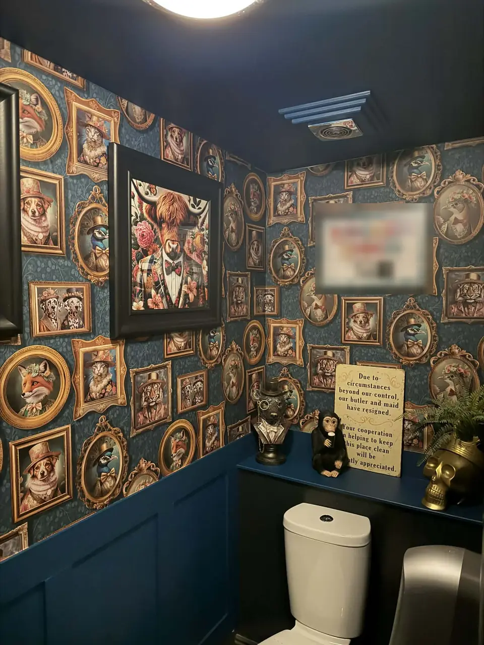 Framed animal portrait wallpaper above deep blue panelling, with a dark ceiling