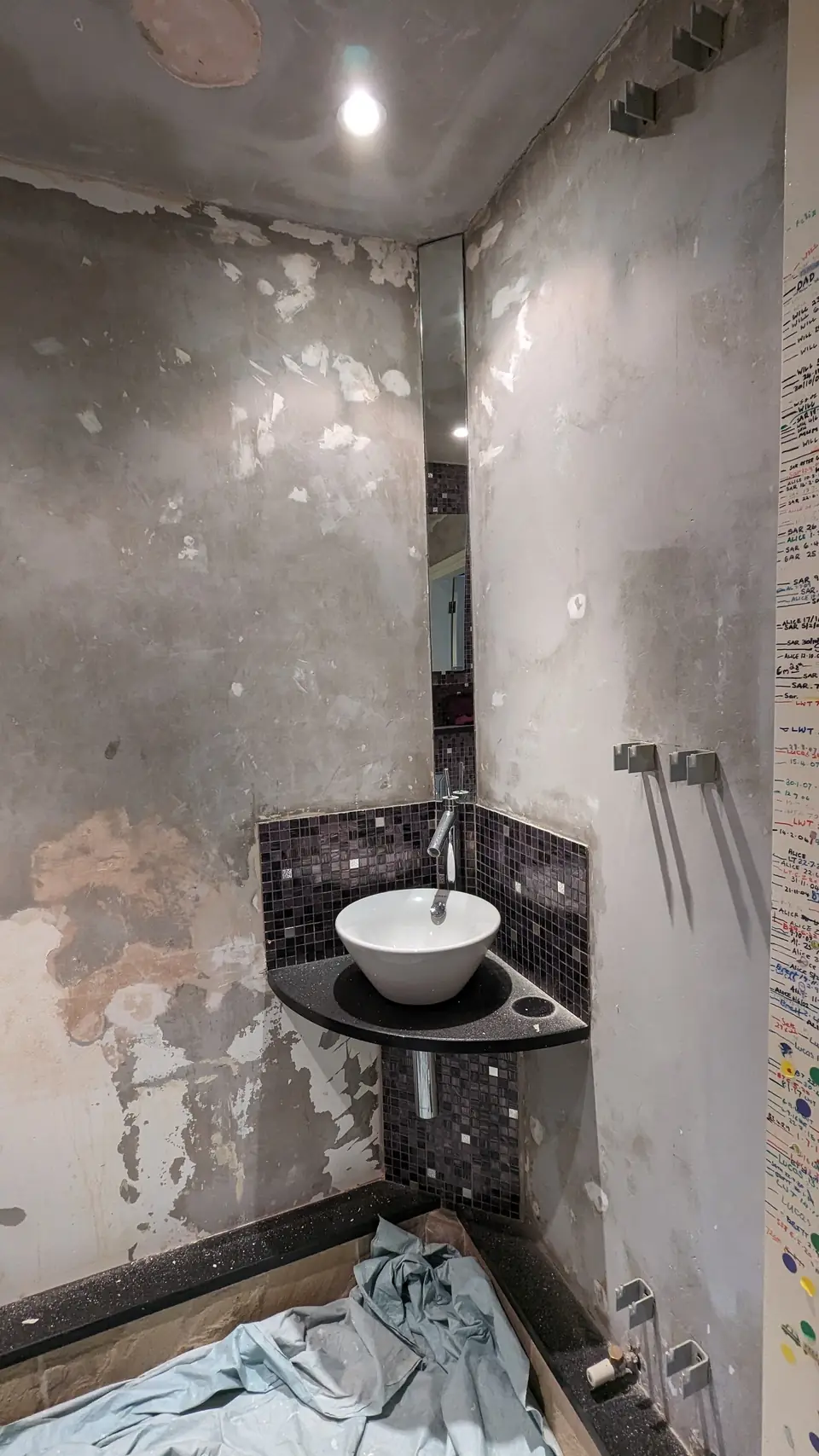 Before: cloakroom corner basin, walls stripped