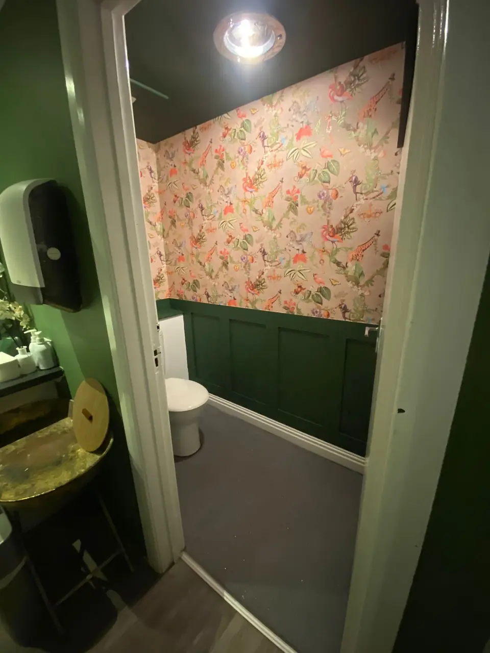 Through the doorway: jungle wallpaper and green panelling