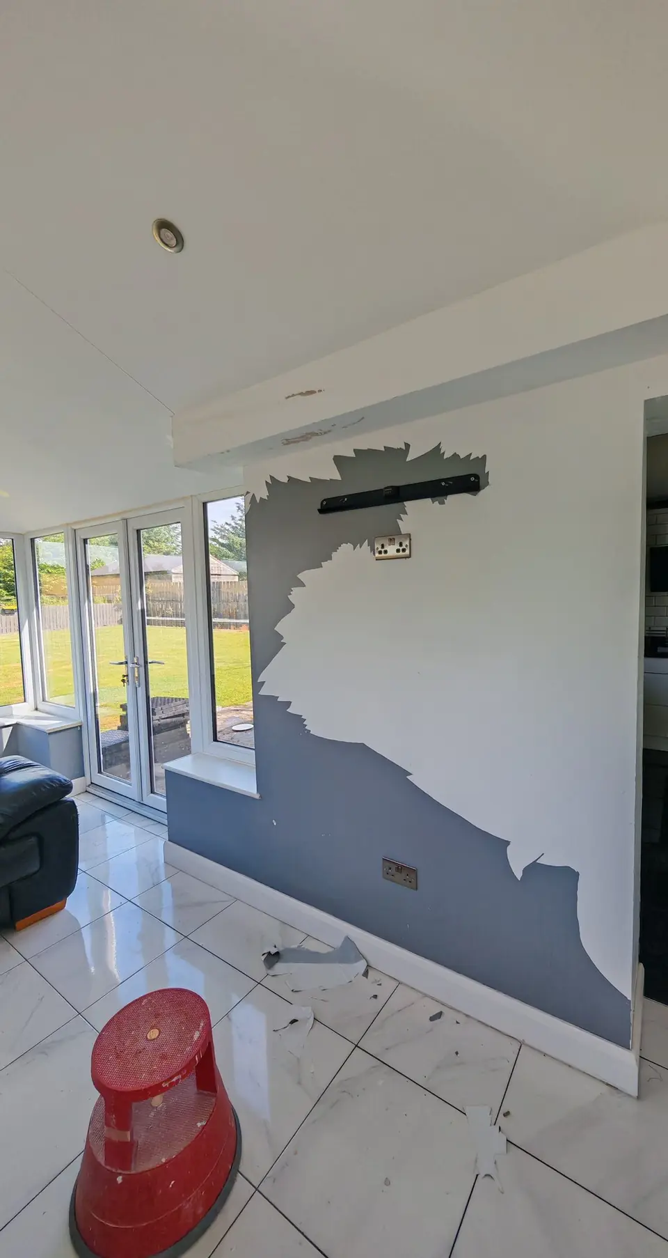 Before: feature wall with the old grey wallpaper half stripped