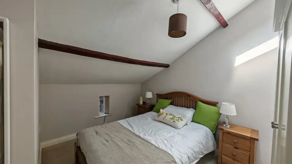 Cottage bedroom with vaulted ceiling and beams painted