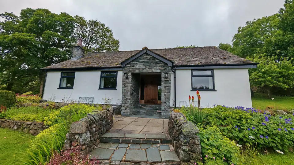 Lake District cottage: white render repainted around the slate stone porch