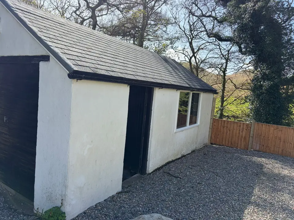 Before: the garage and outbuilding, weathered render