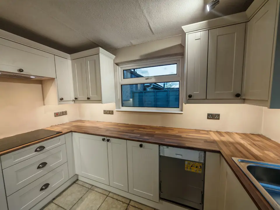 Cream shaker kitchen with a wood-effect worktop, with freshly decorated walls and ceiling