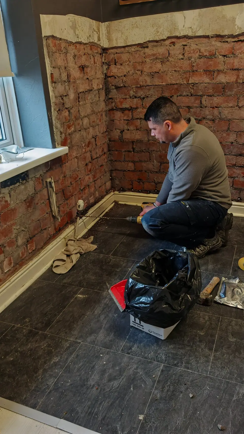 During: drilling along the brick course for damp treatment