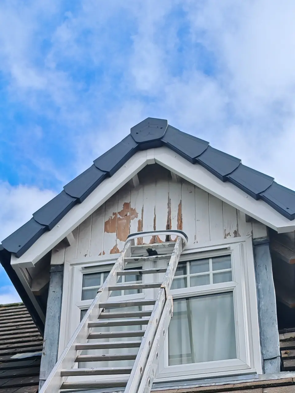 Before: dormer cladding with flaking paint and bare wood, ladder up
