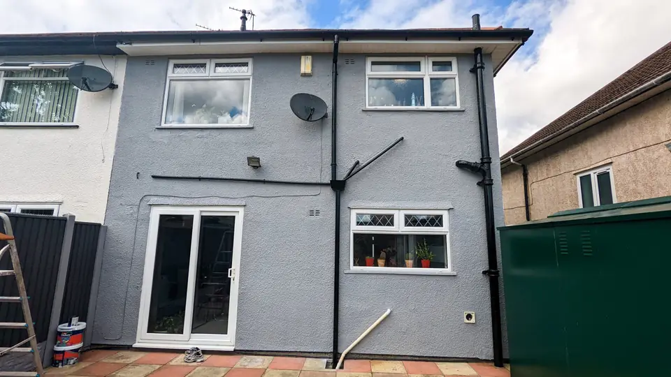 Rear elevation of a house painted in grey masonry paint