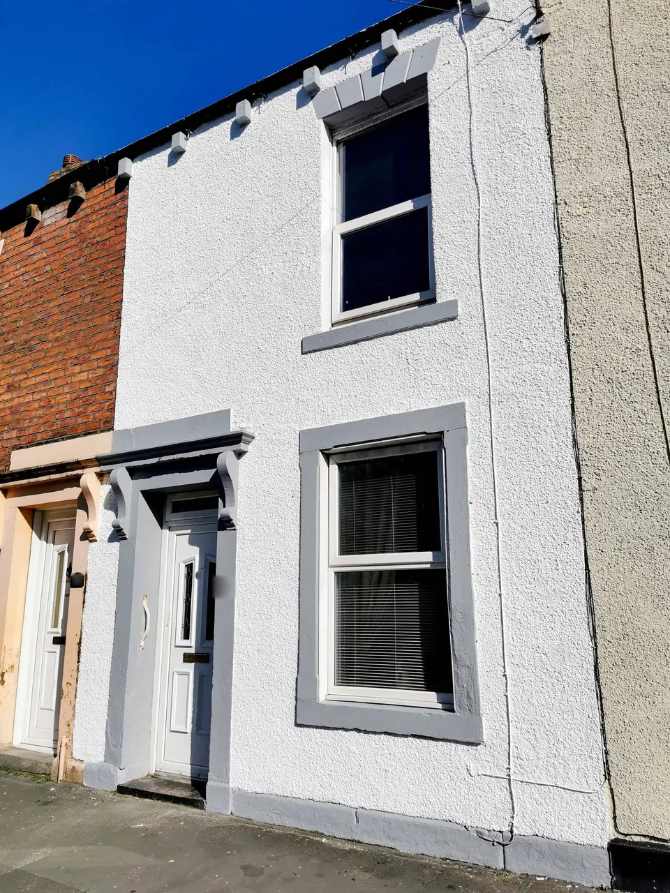 White terraced house with grey window surrounds