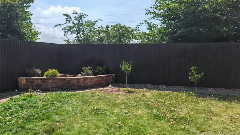 Fence and side gate re-coloured from orange-red to dark brown: the garden fence behind the raised bed