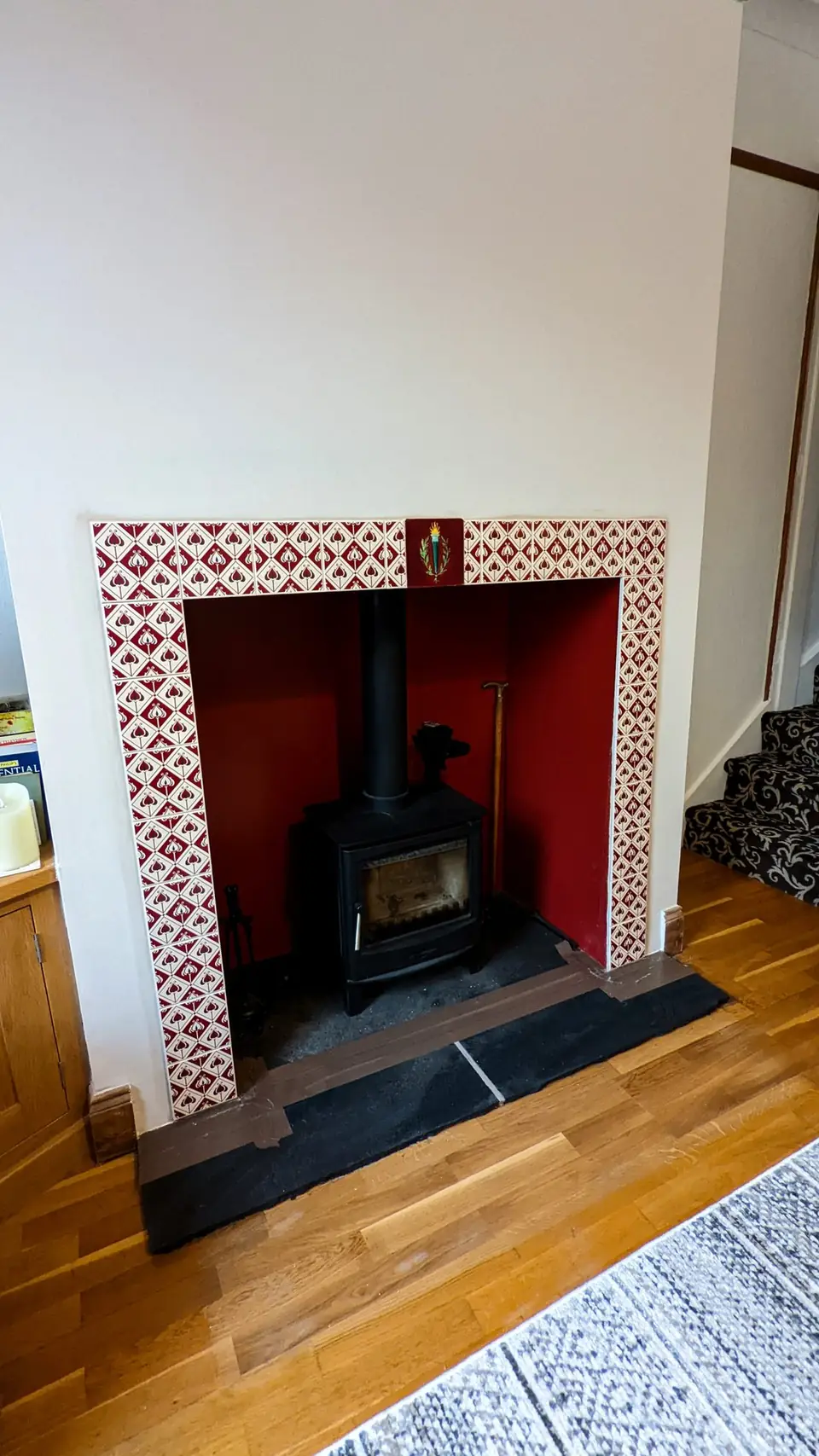 Fireplace with red painted surround and log burner