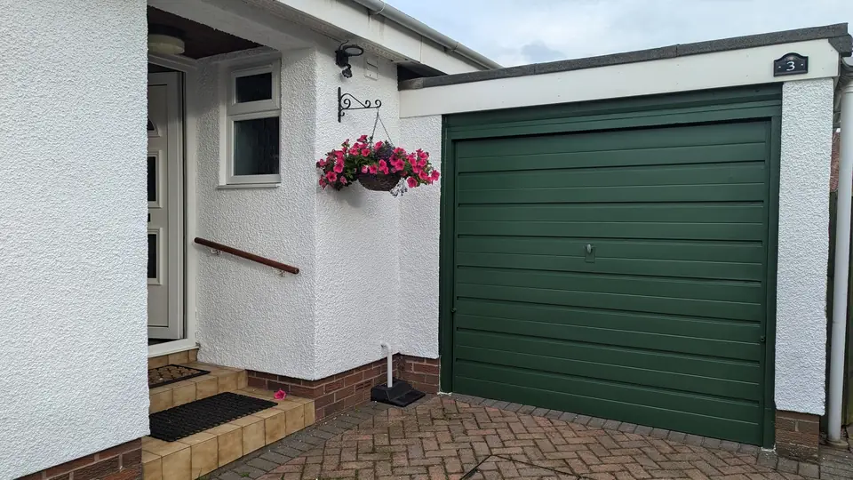 Dark green garage door and white walls