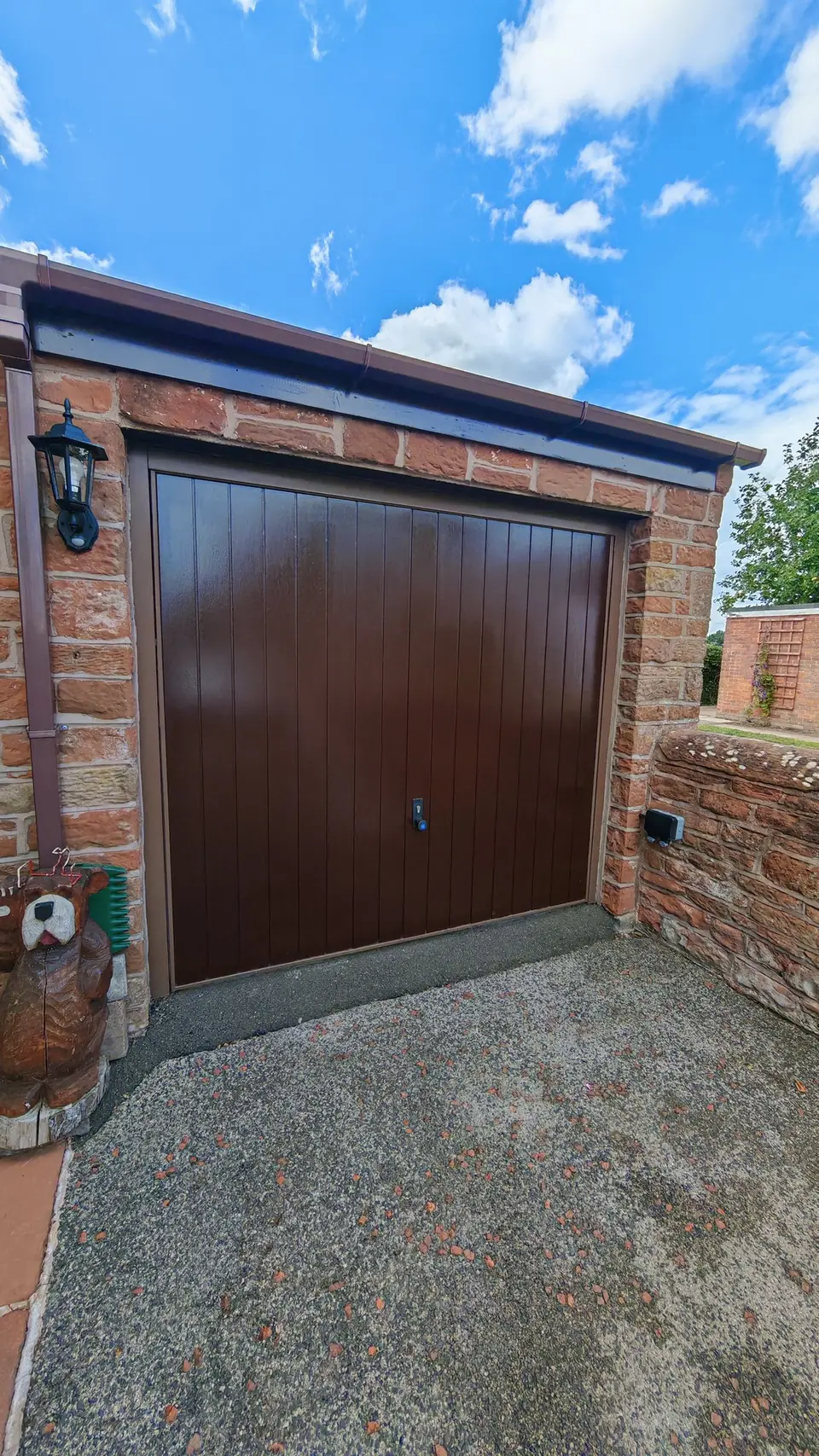 Garage door respray: finished in brown, sandstone garage under blue sky