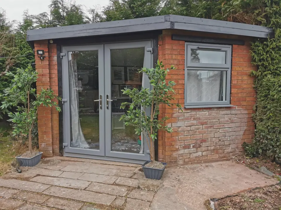 Brick garden room with grey French doors and window, finished and tidied