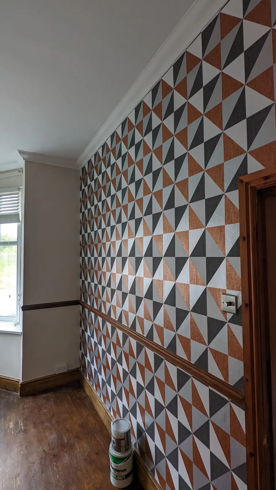 Geometric triangle-pattern wallpaper on a long feature wall