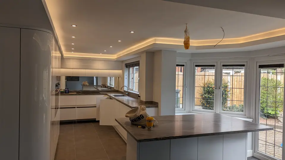Open-plan white gloss kitchen with an island and bay windows, freshly decorated