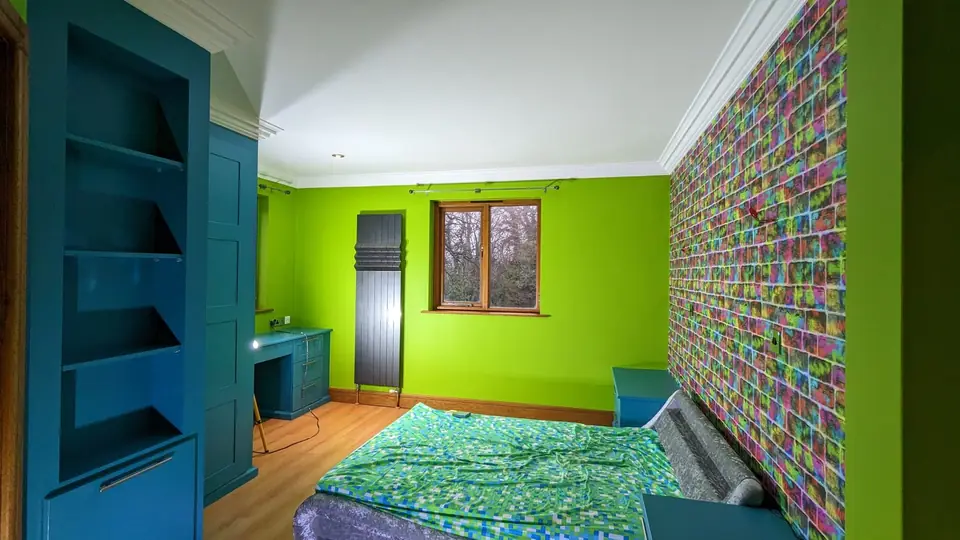 Child's bedroom in lime green with teal painted shelving and feature wallpaper