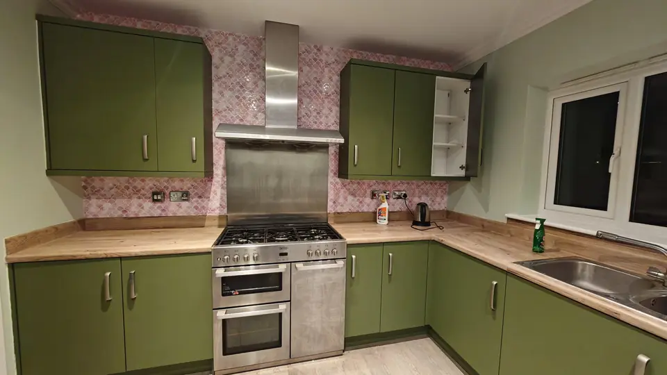 Pink marble fish-scale splashback tiles around the hob