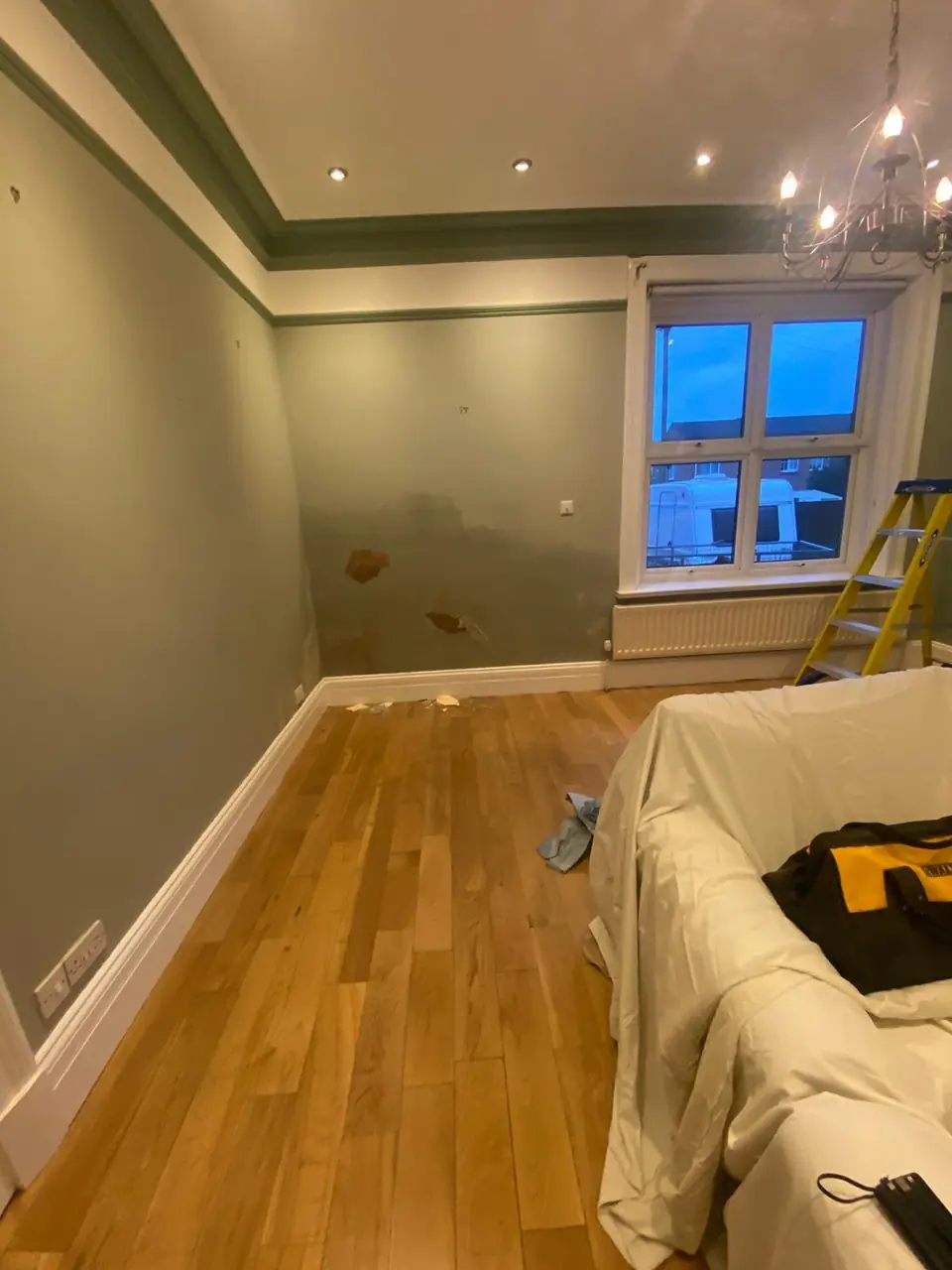 Before: damp-stained corner wall with blown paint
