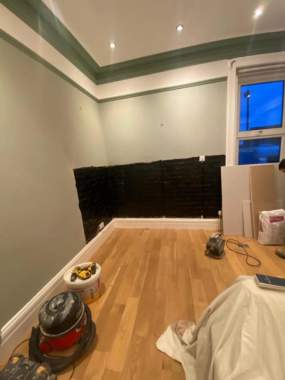 During: plaster stripped, brick coated in black damp seal, new boards ready