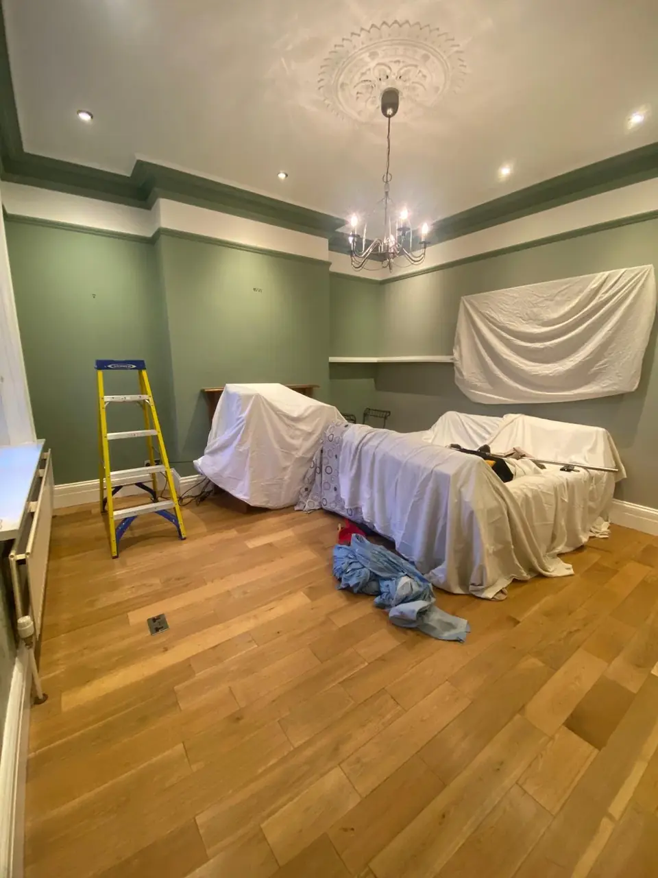 Before: the sage green room with furniture under dust sheets