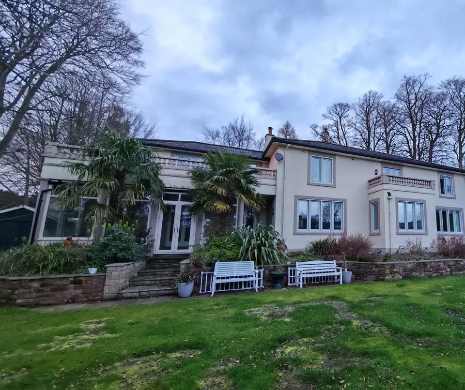 The whole house from the lawn: windows and doors painted sage green