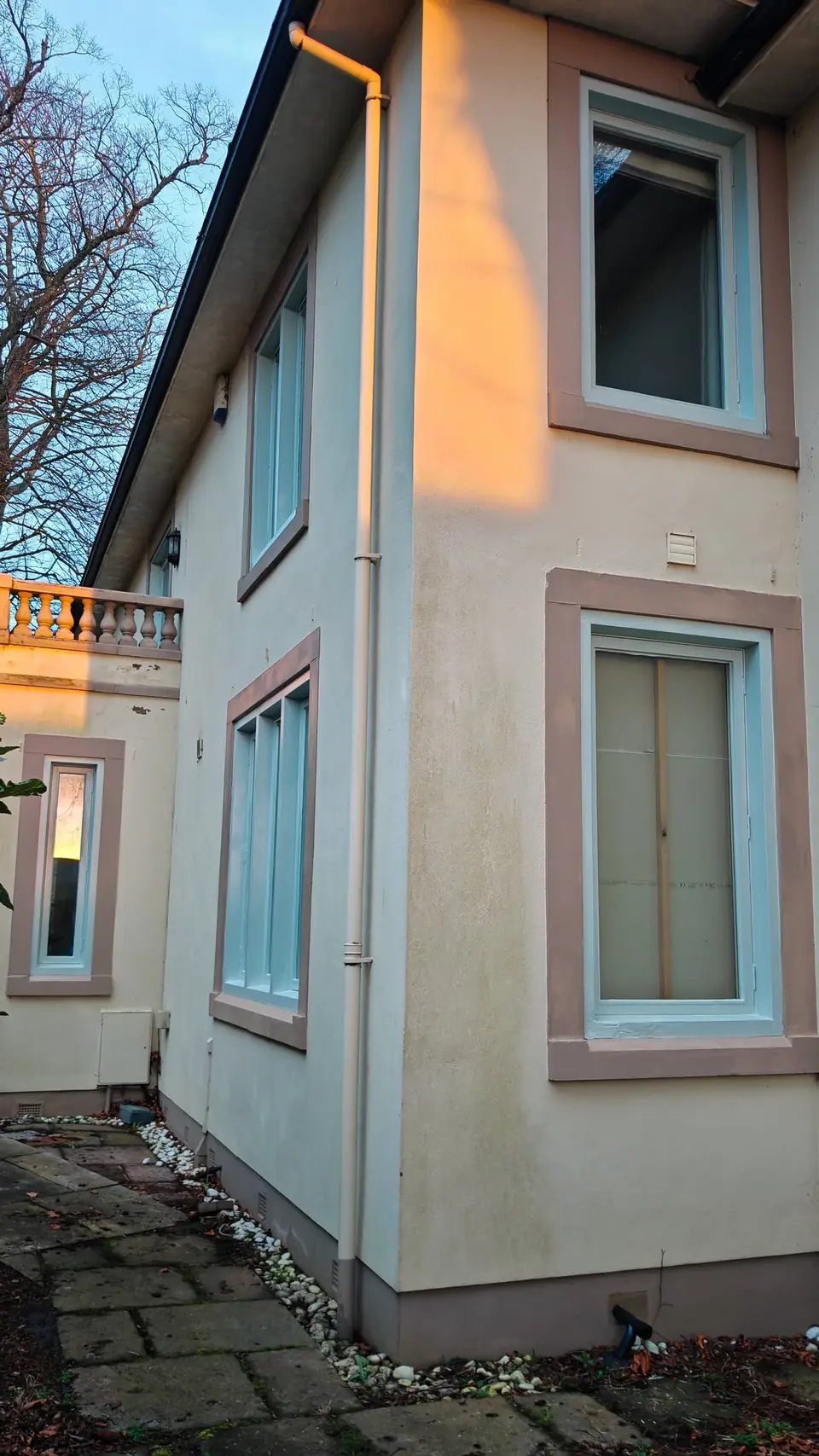 Side elevation: timber windows painted sage green inside stone surrounds