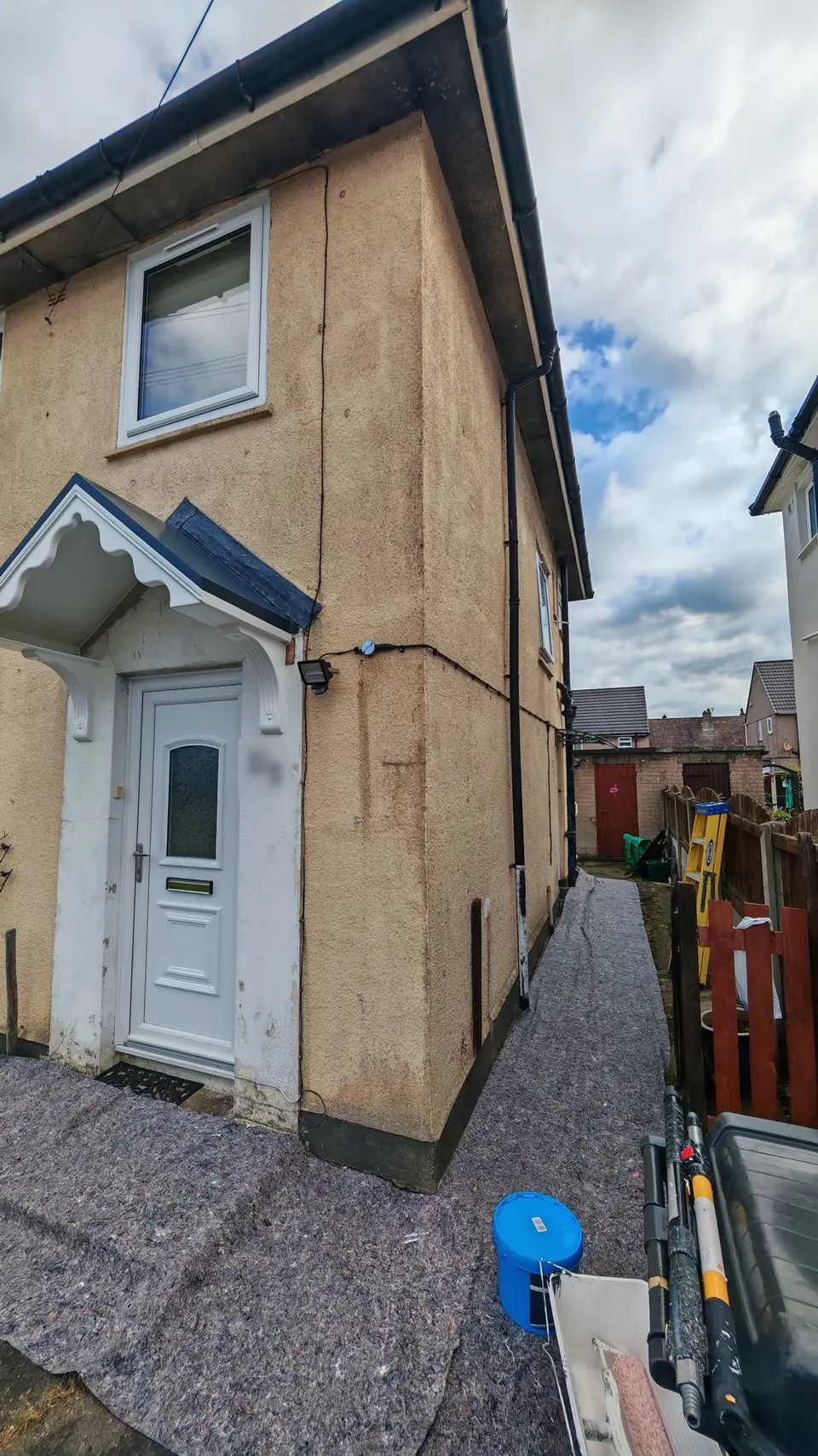 Before: weathered cream render by the front door