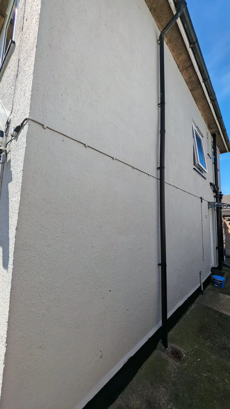 After: gable wall in light grey with a crisp black plinth line