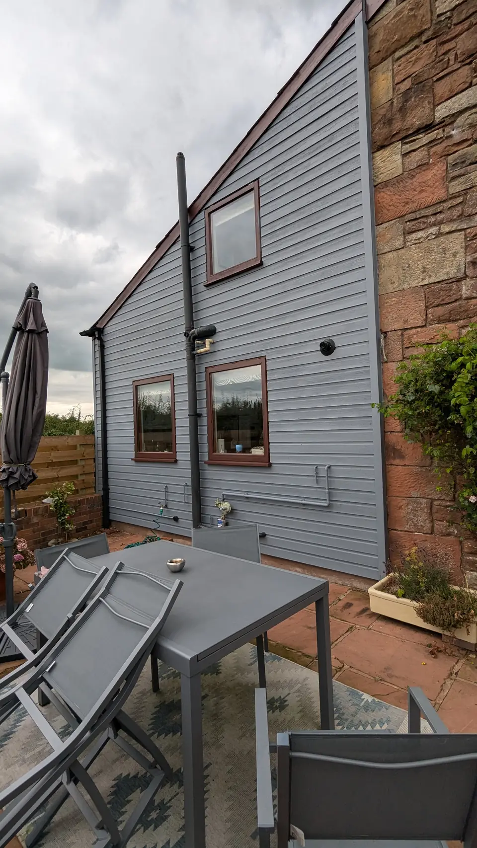 Extension clad in grey painted timber boards