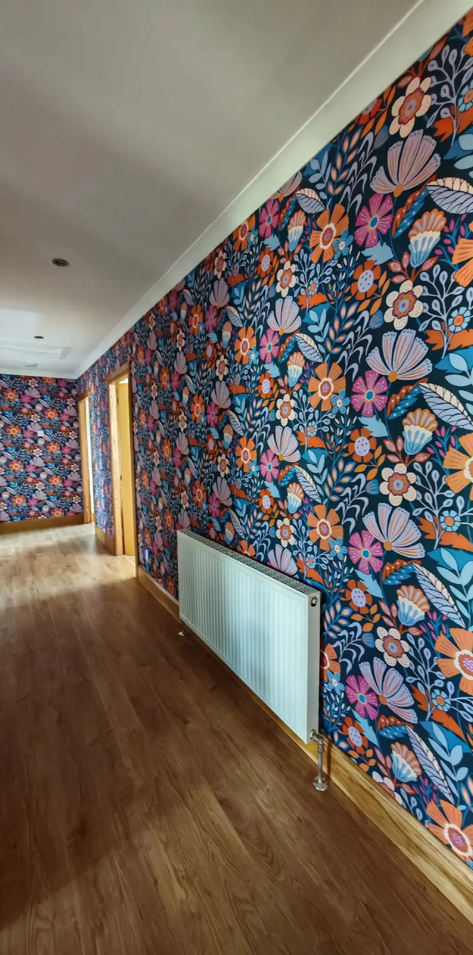 Bold floral wallpaper running the length of the hallway