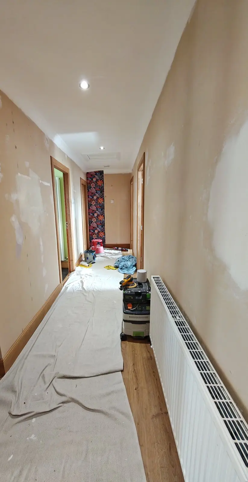 Before: the long hallway with filled and sanded walls, dust sheets down