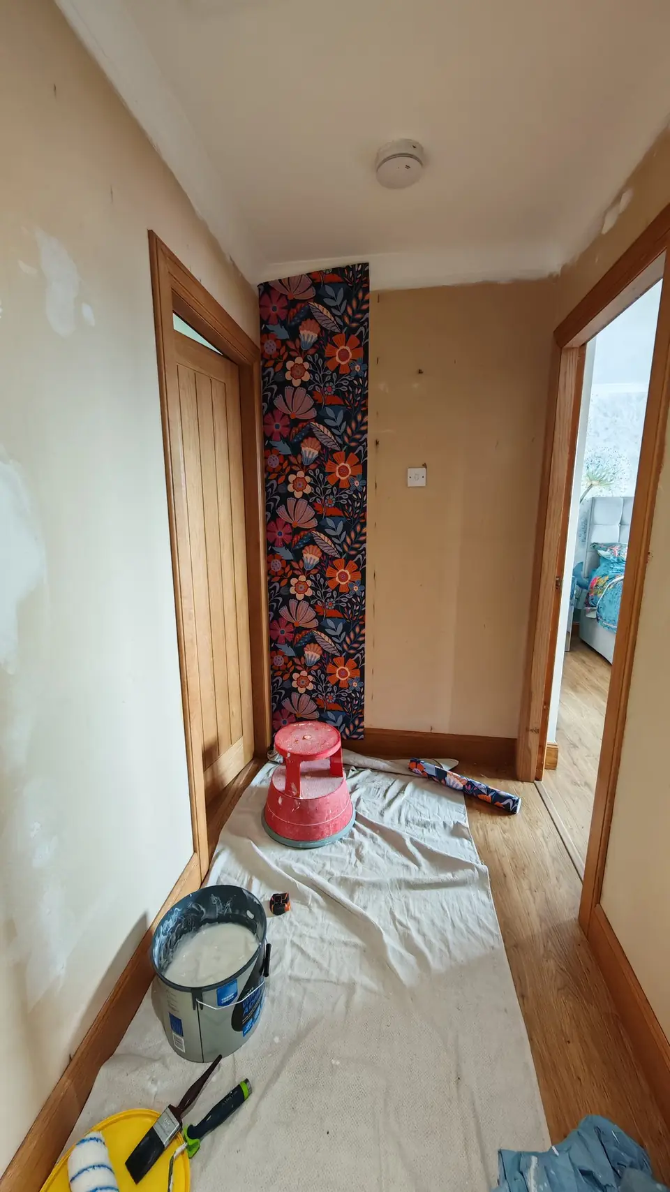During: the first drop of floral paper hung