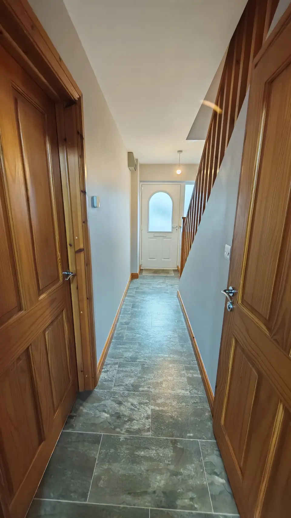 Grey hallway with oak doors leading to the front door