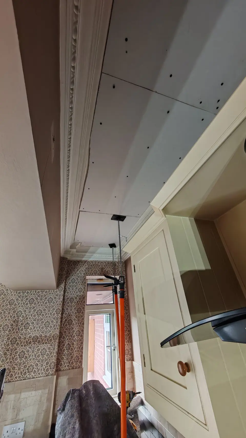 During: new plasterboard propped up and fixed over the old ceiling