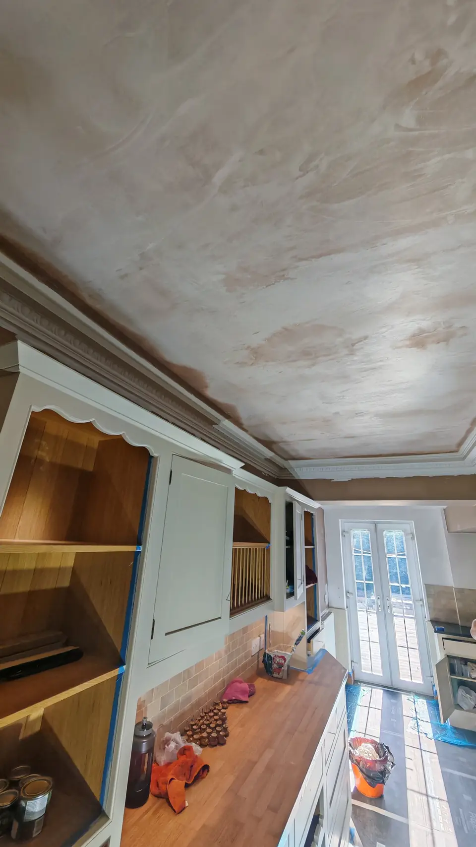 Before: freshly skimmed pink plaster ceiling, cream units masked