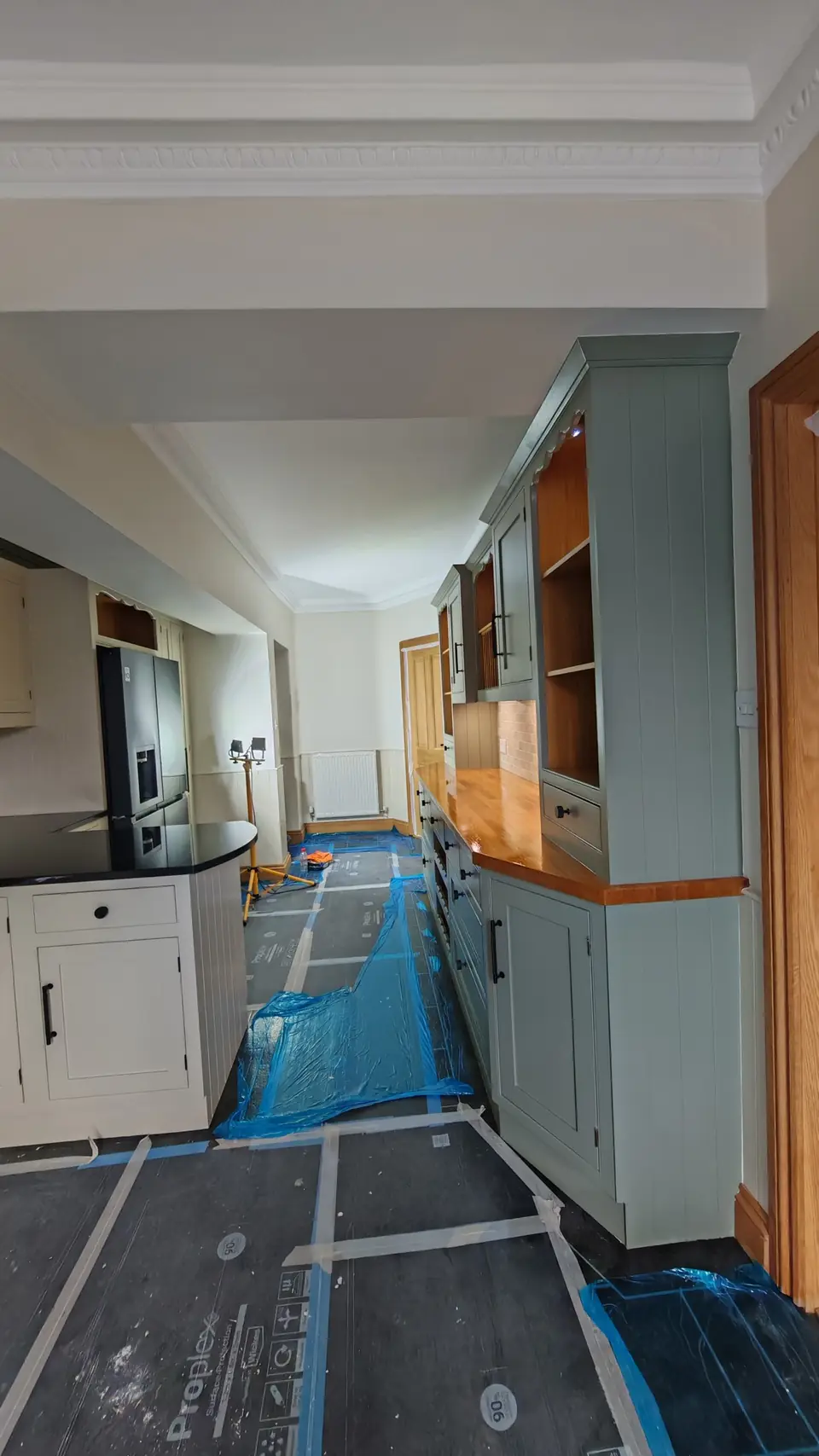 Sage green painted dresser with oak worktop, long view down the kitchen